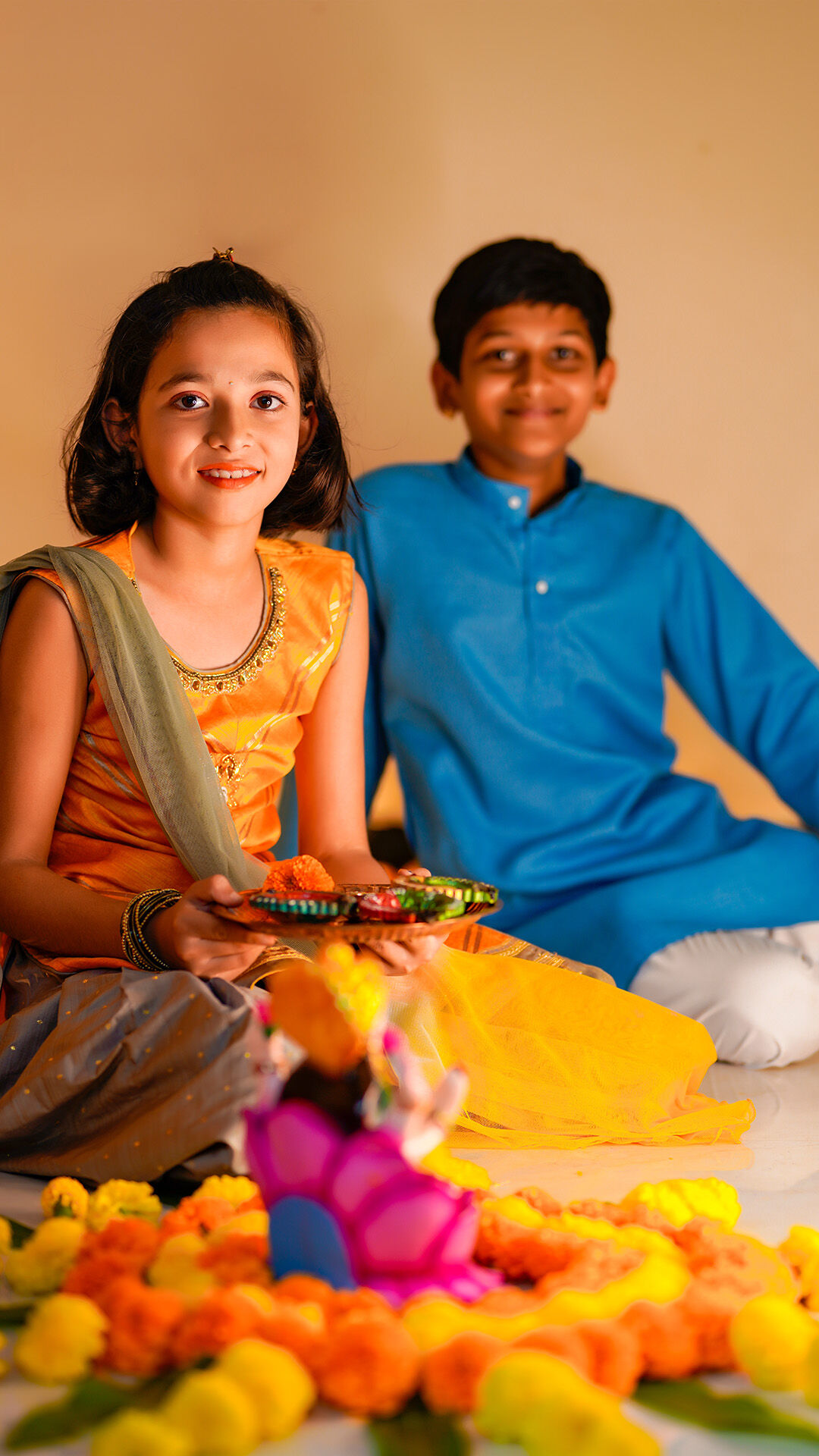 Brother and sister smiling, exchanging beautifully wrapped shagan gifts for the Bhai Dooj festival.